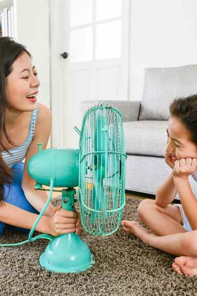 two girls using fan